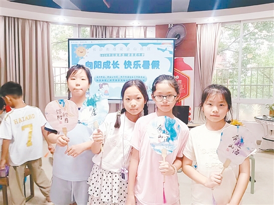 孩子们展示亲手描绘的漆扇。