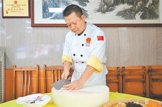 易兆林在一条鲩鱼上熟练地施展刀功。