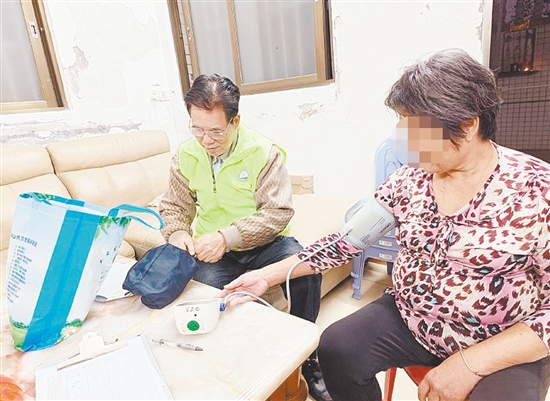 家庭医生挨家挨户为患病老人测量血压和血糖。