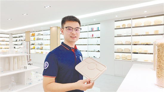 贺健平展示自家公司的产品——用可生物降解新材料制成的餐盒。