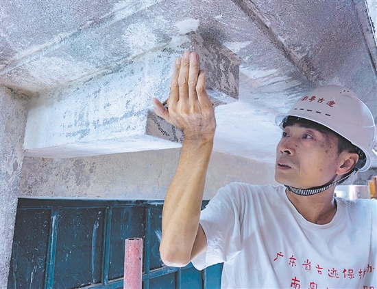 欧阳仑在长堤历史文化街区勘察骑楼的水刷石工艺。