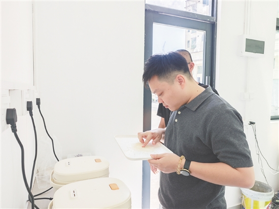 工作人员从多款成品大米样品中取样蒸煮，把控品质、检验口感。