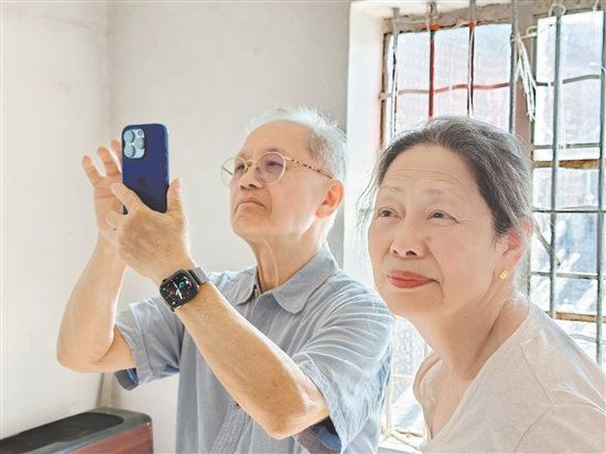伍爵彬与夫人余纾华探访祖屋期间,多次拿出手机拍照纪念。 伍爵彬与夫人余纾华探访祖屋期间,多次拿出手机拍照纪念。