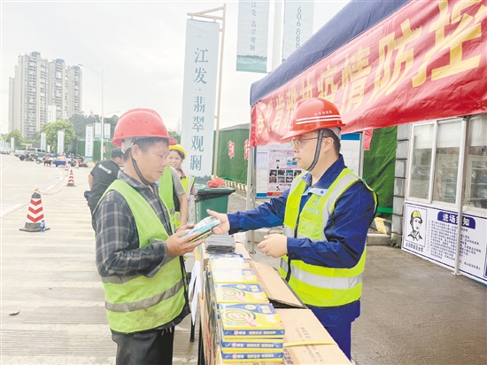 工地施工人员排队领取防蚊用品。